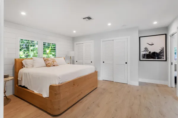 a spacious bedroom with a bed and a painting on the wall