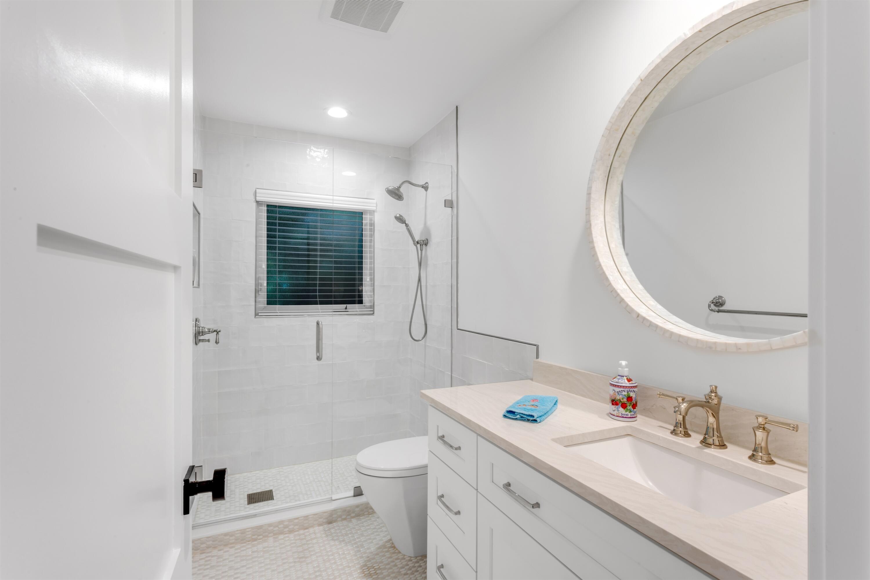 2720 Cardinal Circle Gulf Stream, FL 33483 - Photo 18 of 28 a bathroom with a sink a toilet and a mirror
