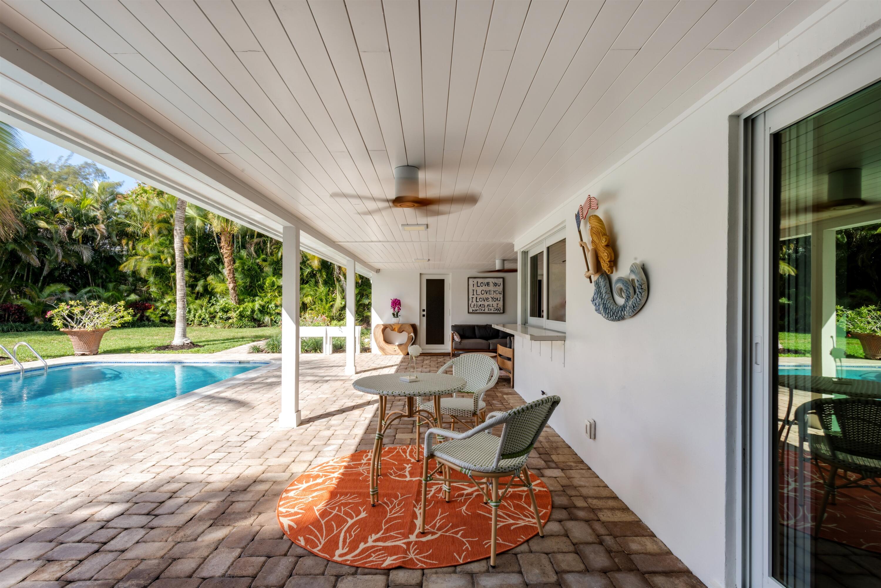 2720 Cardinal Circle Gulf Stream, FL 33483 - Photo 23 of 28 a living room with patio furniture and a floor to ceiling window
