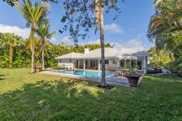 a view of a house with backyard and sitting area