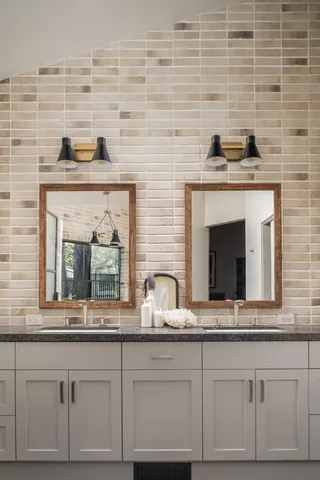 a kitchen with granite countertop a sink cabinets stainless steel appliances and a large window