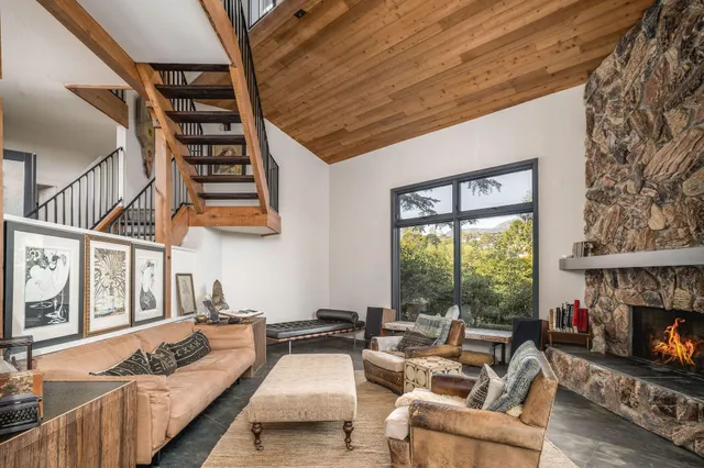 a living room with furniture a fireplace and a floor to ceiling window