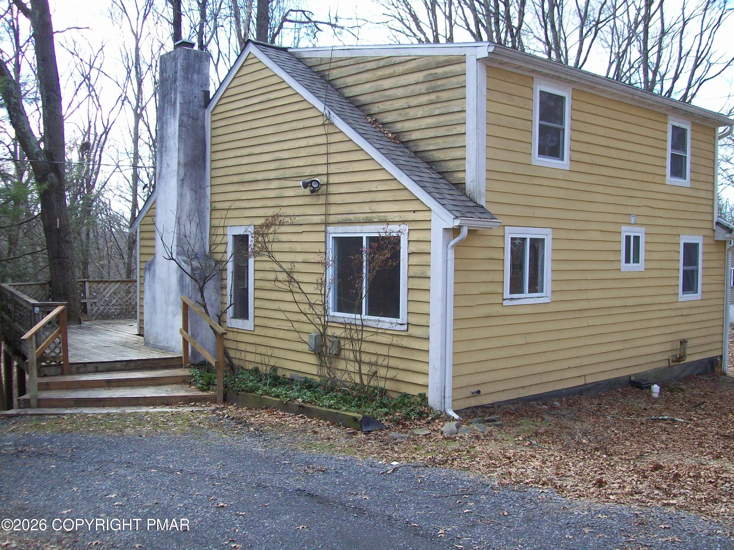a view of a house with backyard and wooden fence