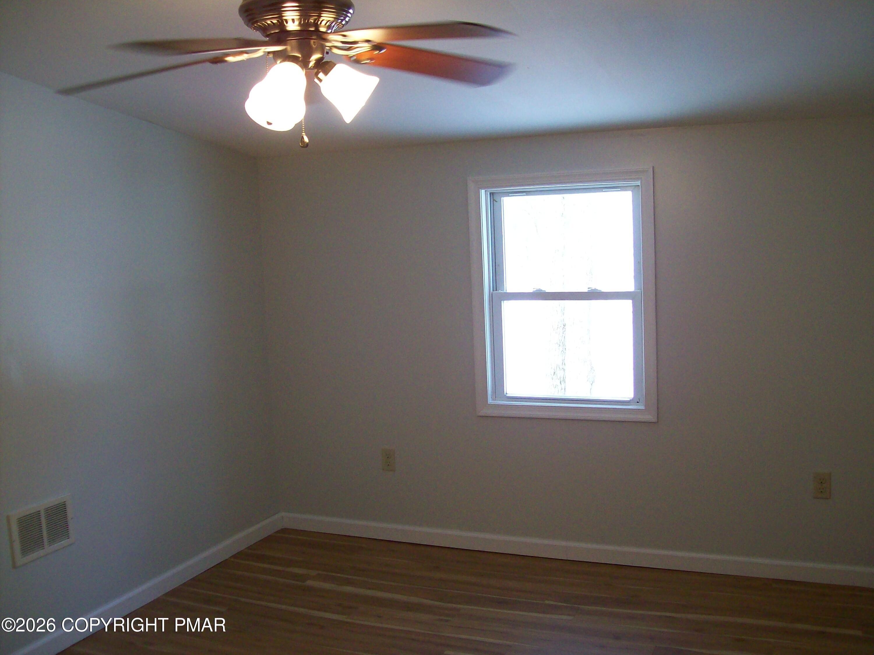 522 Apache Road East Stroudsburg, PA 18302 - Photo 13 of 23 a view of an empty room with wooden floor and a window