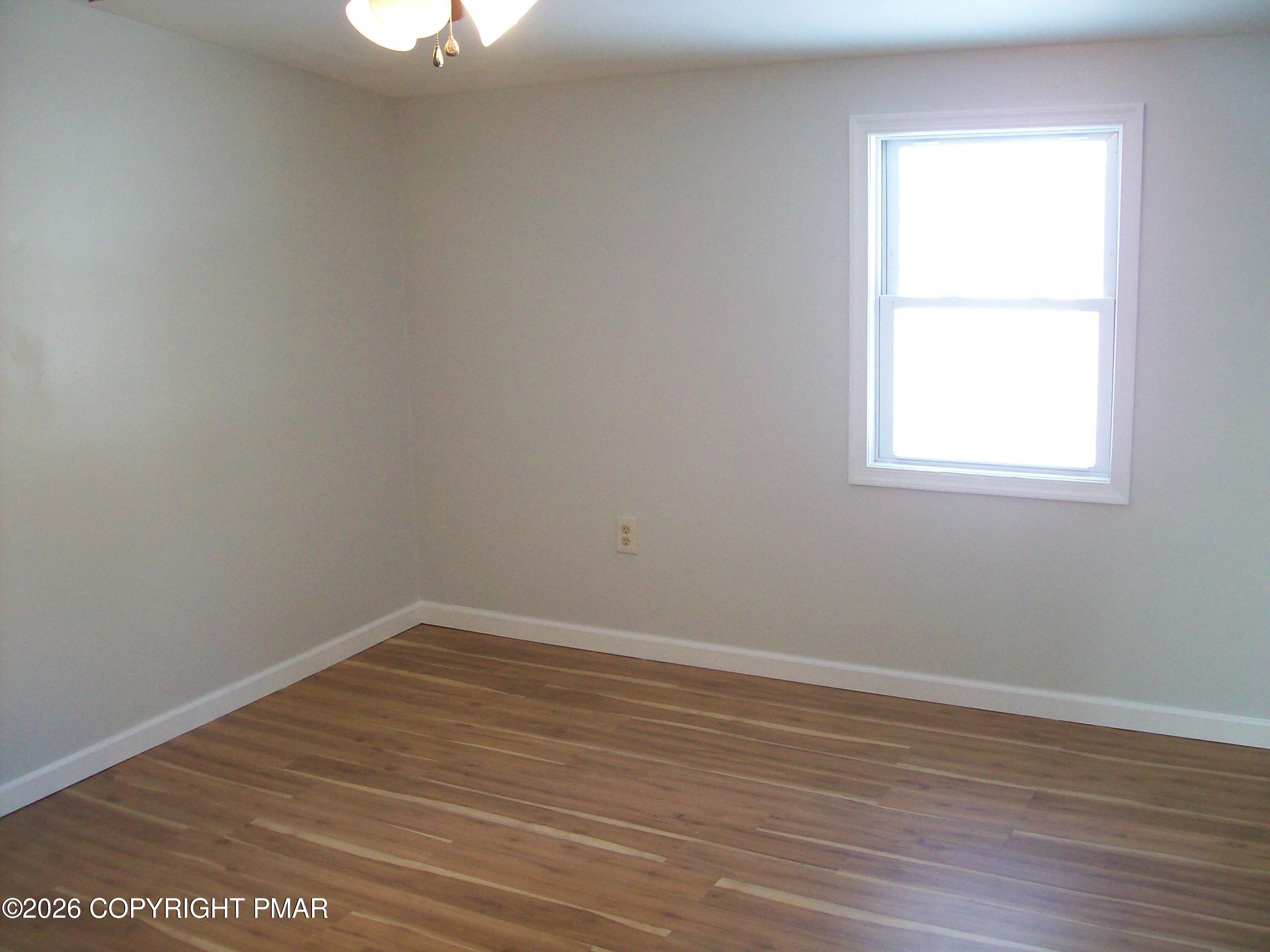 522 Apache Road East Stroudsburg, PA 18302 - Photo 17 of 23 an empty room with wooden floor and windows