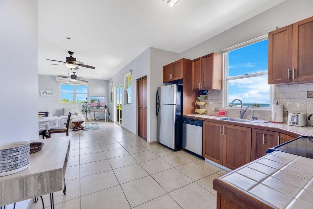 413 Camino Carretas, Unit A7 Rincon, Rincón 00677 - Photo 7 of 23 a kitchen with stainless steel appliances kitchen island granite countertop a refrigerator and a sink