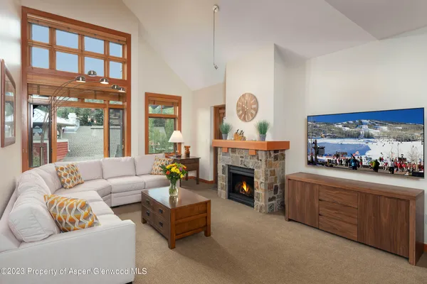 a living room with furniture a fireplace and a large window