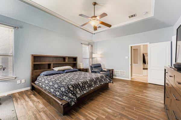 602 Christa Street Ovilla, TX 75154 - Photo 15 of 23 Bedroom with wood finished floors, a tray ceiling, multiple windows, and ornamental molding