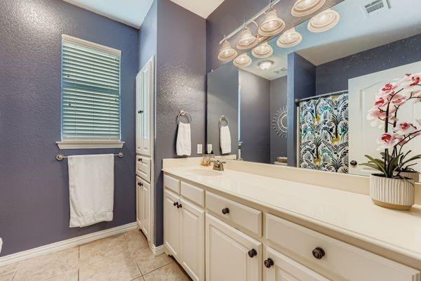 602 Christa Street Ovilla, TX 75154 - Photo 19 of 23 Full bath with a shower with shower curtain, vanity, light tile patterned floors, and a textured wall