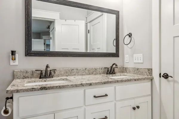 a bathroom with cabinets sink and mirror