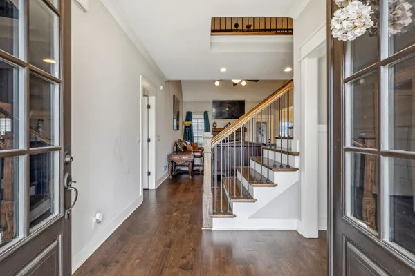 a view of a hallway with wooden floor and staircase