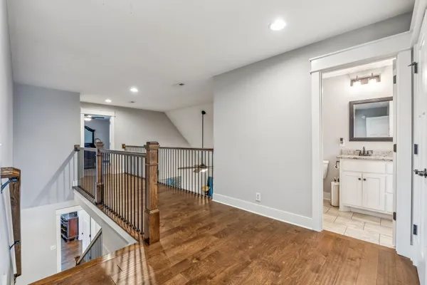 a view of a hallway with wooden floor and staircase