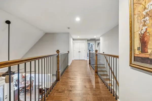 a view of a hallway with wooden floor and stairs