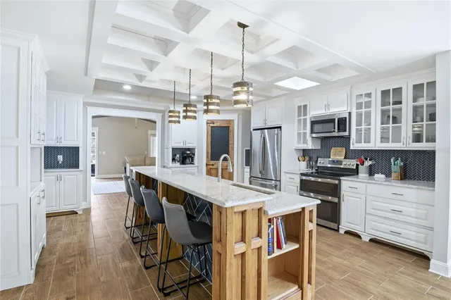 a kitchen with granite countertop a table chairs stainless steel appliances and cabinets