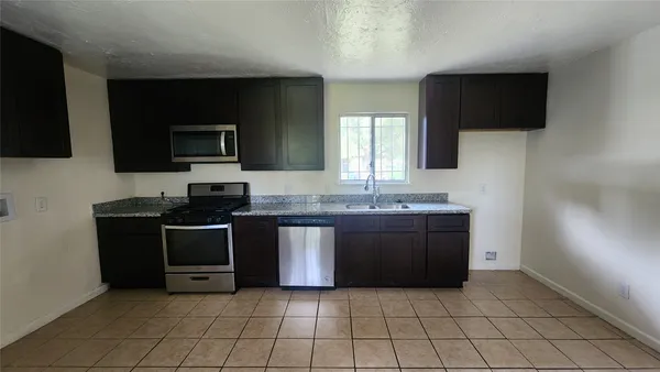 a kitchen with stainless steel appliances granite countertop a stove and a microwave oven on the blue kitchen countertops