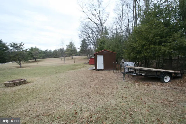 a backyard of a house with barbeque oven and wooden fence