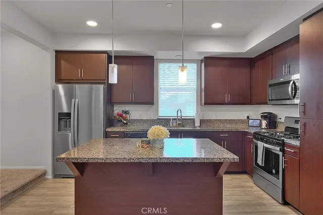 a kitchen with stainless steel appliances granite countertop wooden cabinets a sink and a stove