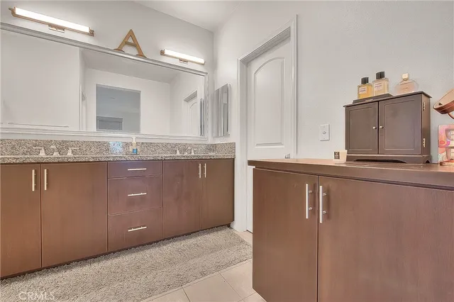 a bathroom with a granite countertop sink a mirror and a vanity