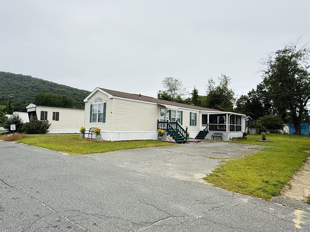 268 Palmer Road, Unit 44 Monson, MA 01057 - Photo 2 of 34 a front view of a house with a yard and garage