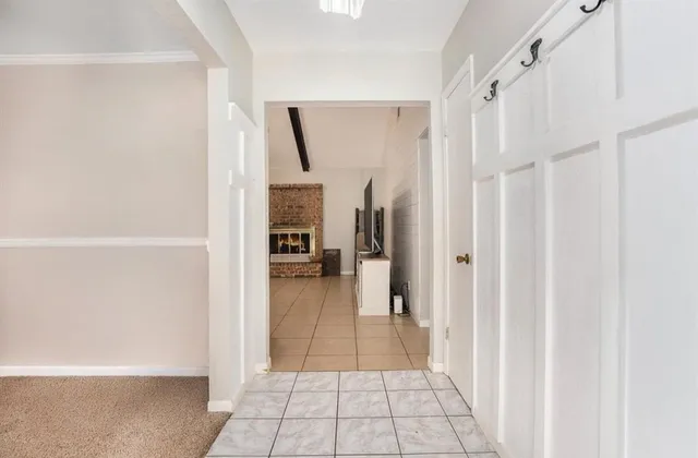 a view of a hallway with a livingroom and a bathroom with bathtub