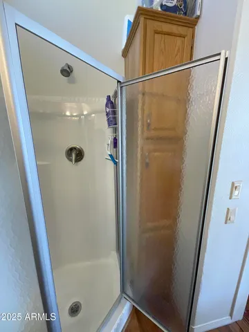 a bathroom with a glass shower door and a sink