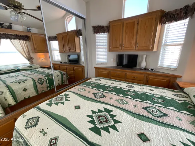 a bedroom with a bed and flat tv screen on dresser