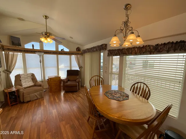 a dining room with furniture a chandelier and wooden floor