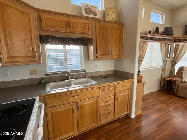 a kitchen with a sink cabinets and a wooden floor
