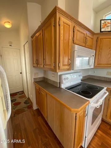 a kitchen that has a sink a stove top oven a refrigerator and cabinets