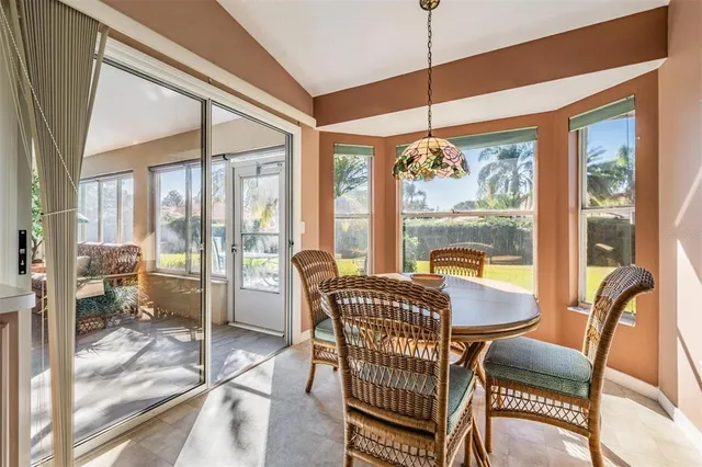a dining room with furniture large windows and a chandelier