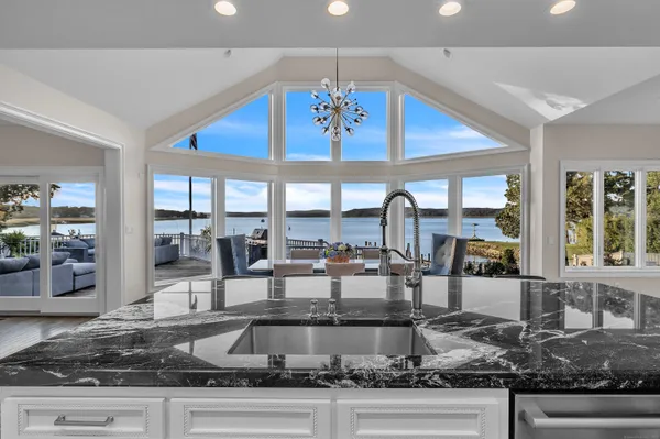 a kitchen with kitchen island granite countertop a large window and cabinets