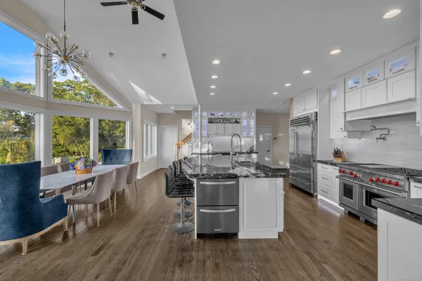 a kitchen with stainless steel appliances a stove a sink a refrigerator and wooden floor