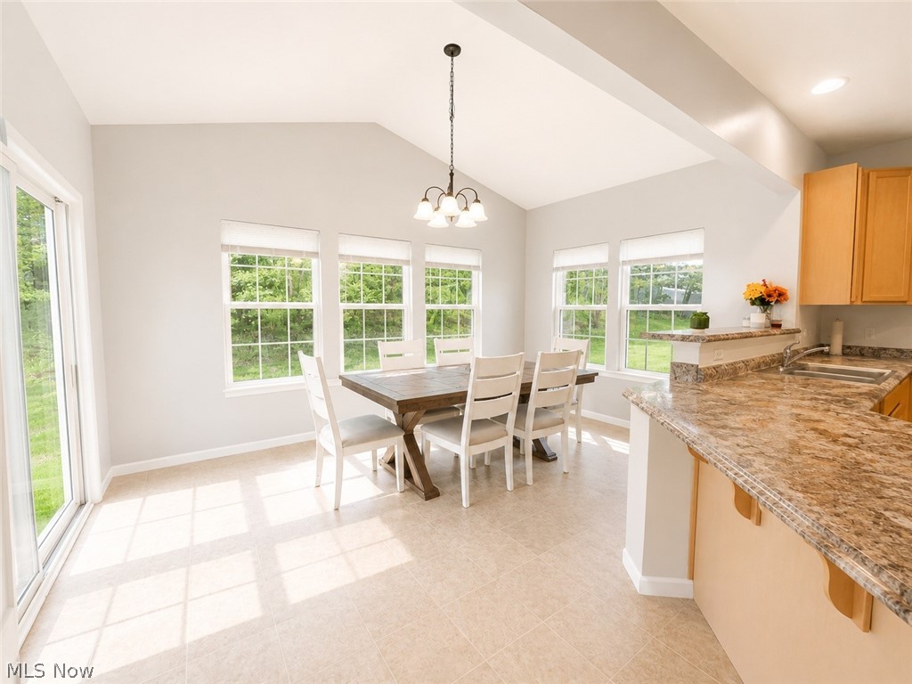 867 Starr Ridge Street Southeast Massillon, OH 44646 - Photo 11 of 29 Dining area featuring a vaulted ceiling and an abundance of natural light