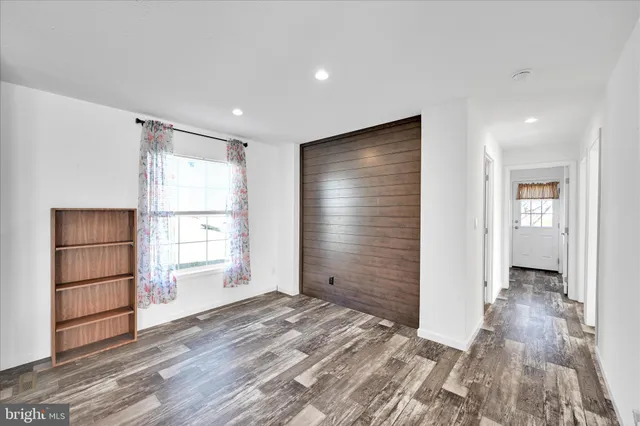 a view of empty room with wooden floor and entryway