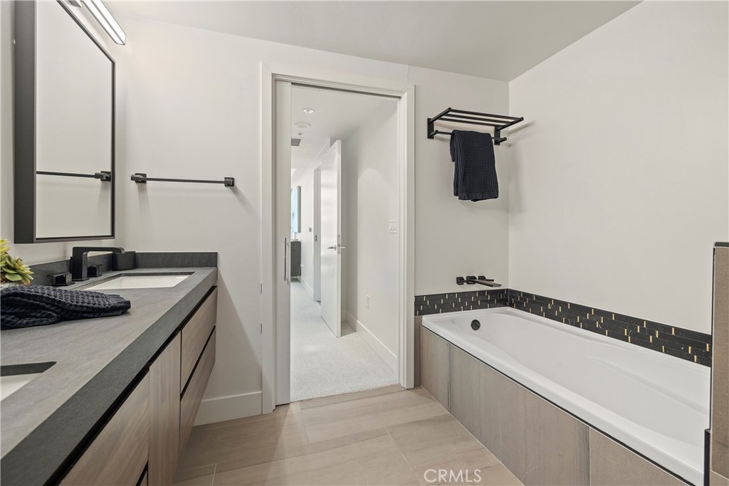 3141 Michelson Drive, Unit 907 Irvine, CA 92612 - Photo 23 of 48 a bathroom with a tub sink and mirror