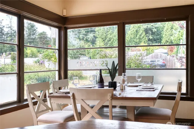 a dining room with wooden floor and a floor to ceiling window