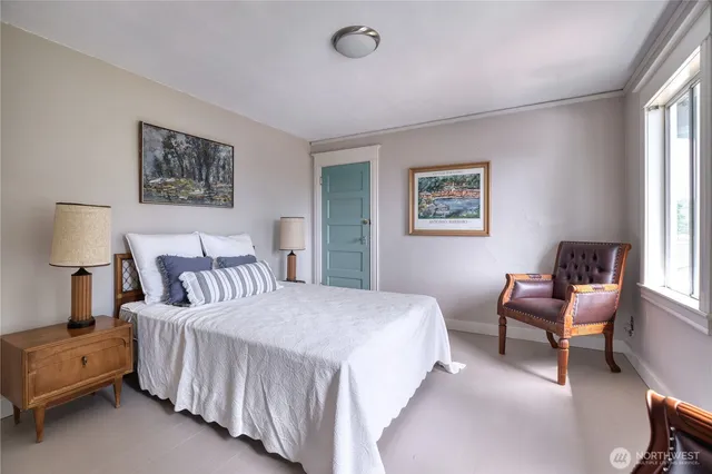 a bedroom with a bed and a lamp on dresser