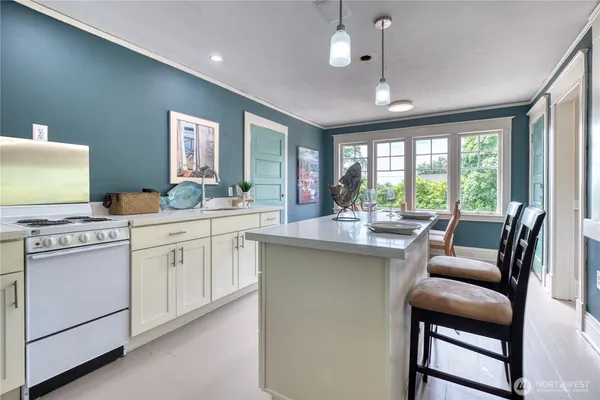 a kitchen with a stove a sink a dining table and chairs