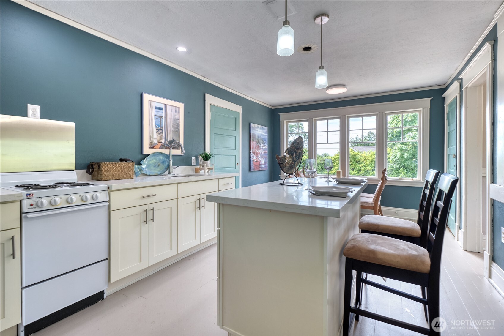 1379 Gulf Road Point Roberts, WA 98281 - Photo 25 of 37 a kitchen with a stove a sink a dining table and chairs