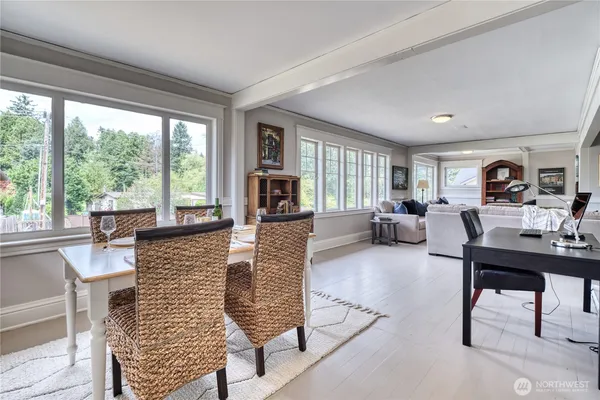 a living room with furniture large windows and wooden floor