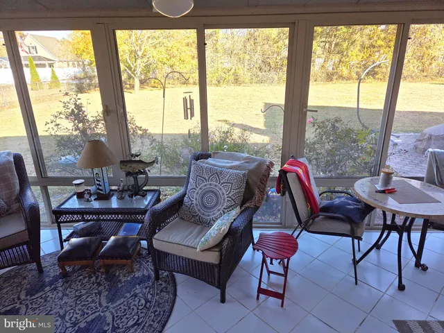 a living room with furniture and a floor to ceiling window