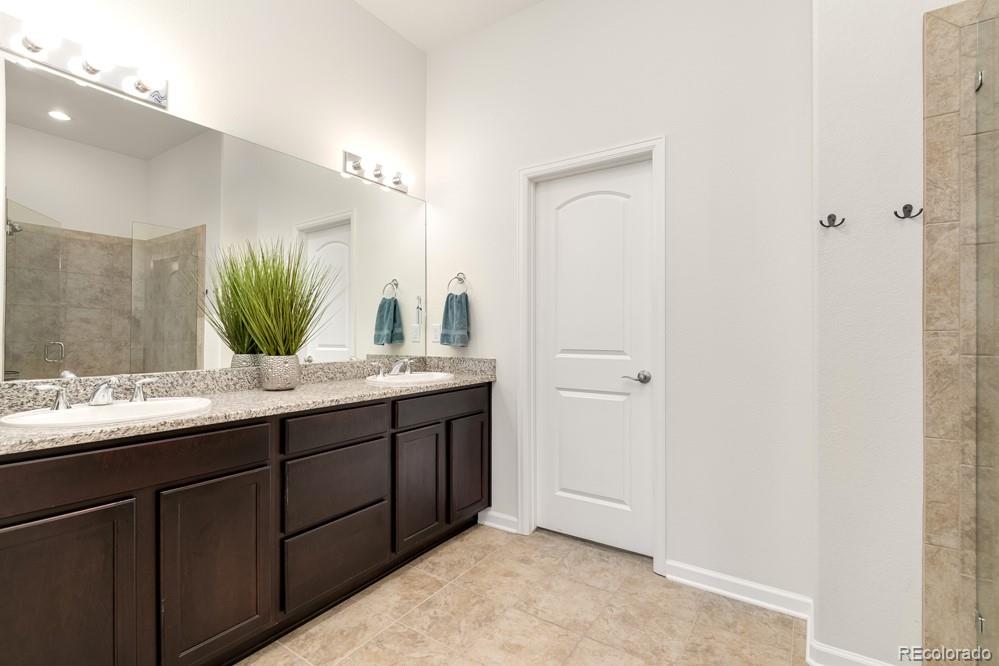 2944 Zephyr Road Fort Collins, CO 80528 - Photo 22 of 35 a bathroom with a granite countertop sink and a mirror