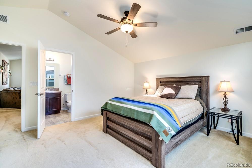 2944 Zephyr Road Fort Collins, CO 80528 - Photo 28 of 35 a spacious bedroom with a bed and a chandelier