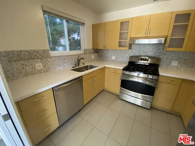 a kitchen with a sink a stove and cabinets