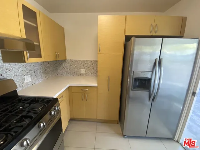 a kitchen with stainless steel appliances granite countertop a refrigerator and a stove