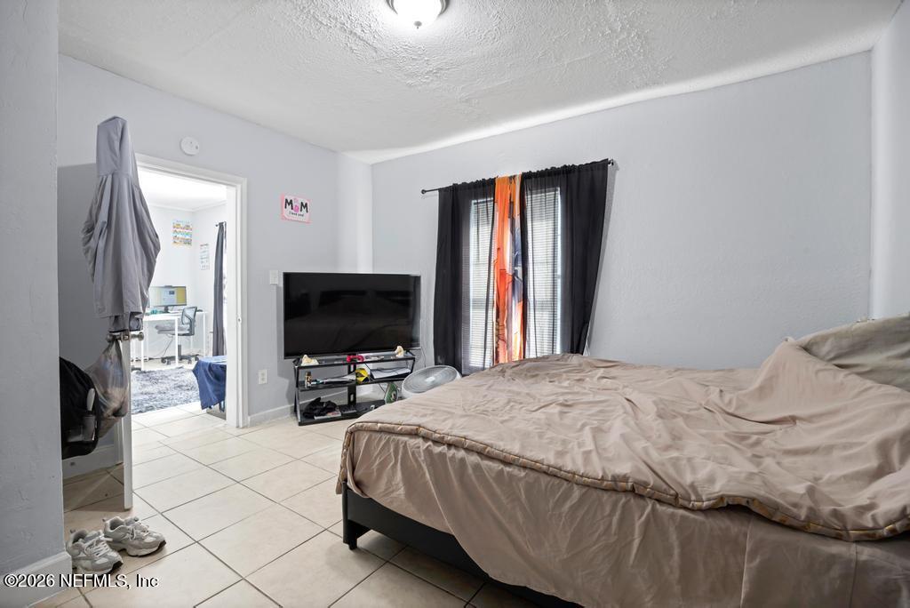 5210 Dodge Road Jacksonville, FL 32209 - Photo 16 of 42 a bedroom with a bed and a flat tv screen on a dresser