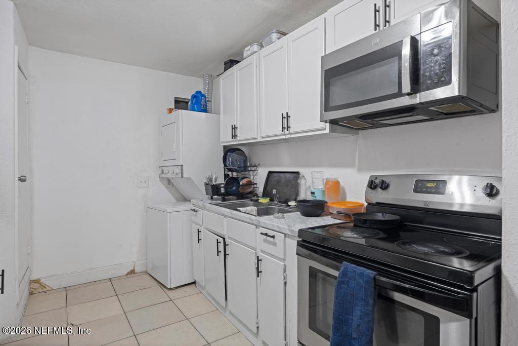 5210 Dodge Road Jacksonville, FL 32209 - Photo 35 of 42 a kitchen with stainless steel appliances granite countertop a stove a microwave and cabinets