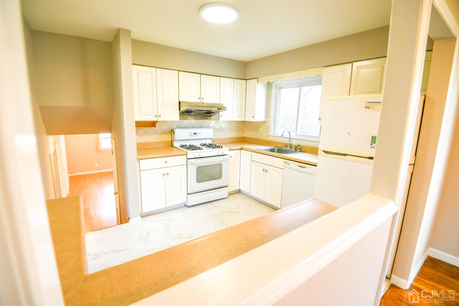 107 Calvert Avenue East Edison, NJ 08820 - Photo 5 of 28 a kitchen with stainless steel appliances granite countertop a stove a sink and a refrigerator