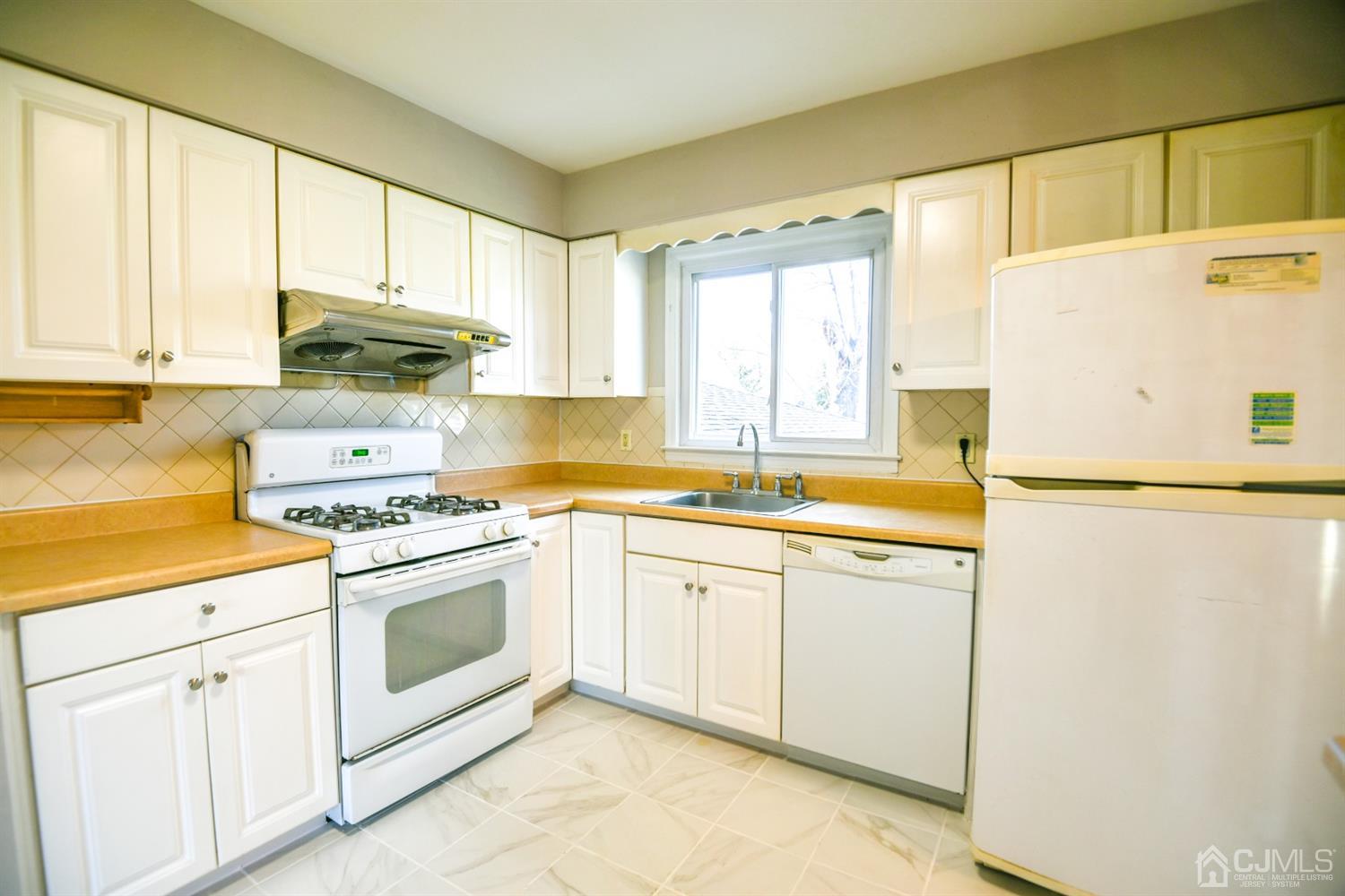 107 Calvert Avenue East Edison, NJ 08820 - Photo 6 of 28 a kitchen with granite countertop white cabinets and white appliances