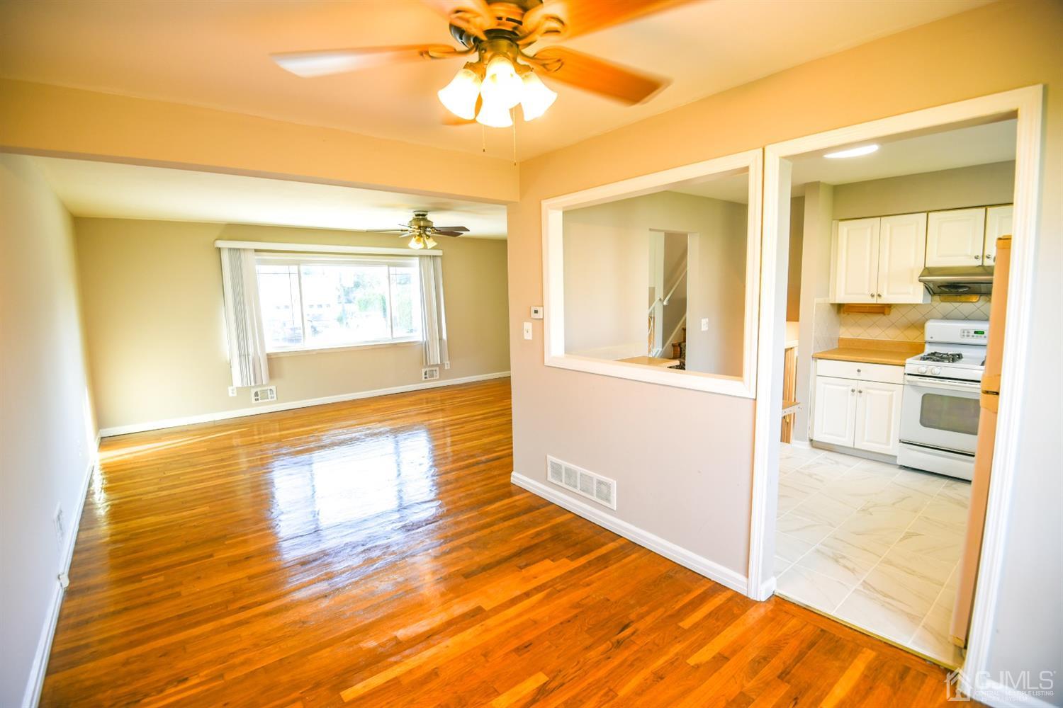 107 Calvert Avenue East Edison, NJ 08820 - Photo 7 of 28 a view of an empty room with wooden floor and a window